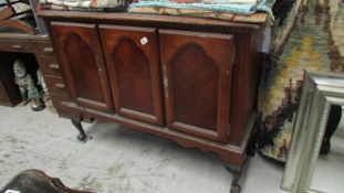 A dark wood stained sideboard with 2 doors & ball & claw feet