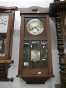 A 1930's oak wall clock with 3 bevelled glass panels