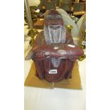 A heavy stone figure of a bearded man presenting a fish