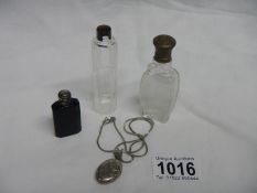 A silver pendant locket on chain and 3 small old scent bottles