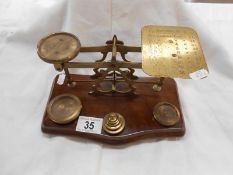An antique postal scales on hardwood base complete with weights