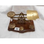 An antique postal scales on hardwood base complete with weights