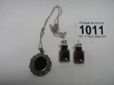 A pair of silver amethyst earrings and a silver black onyx pendant