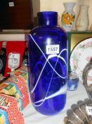 A large blue glass vase with white markings