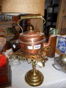 A copper kettle and brass stand