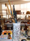 An umbrella stand and contents including walking sticks etc