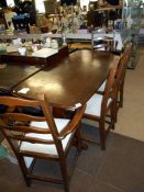 An Ercol style dining table and 4 chairs (including 1 carver)