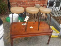 A coffee table and three stools