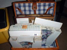 A picnic basket full of plates and prints