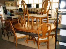 An oak dining table with 5 upholstered chairs