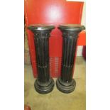 A pair of tall pedestals