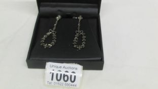 A pair of Edwardian long marcasite pendant earrings surmounted by ribbons in silver