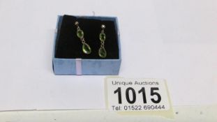 A pair of 9ct gold and peridot drop earrings