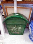 A green painted metal wall mounted letter box