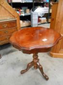 A dark wood stained tripod table with decorative top