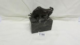 A bronze bull on marble plinth signed L Carim