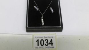 A 10ct white gold tanzanite and diamond pendant and earring set