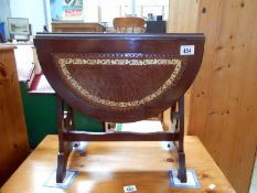 A darkwood drop leaf table with leather seats