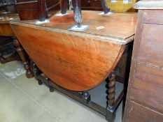 An oak gateleg table with barley twist legs