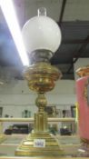 A brass oil lamp complete with shade and chimney