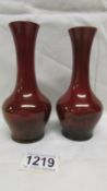 A pair of Ruby lustre hazeldene flambe' vases by William Moorcroft,