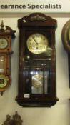 A 1930's oak wall clock with 3 bevelled glass panels