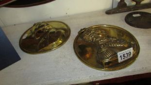 A pair of circular brass plaques depicting Napoleon and Wellington