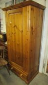 A solid pine single wardrobe with drawer