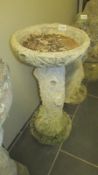 A vintage bird bath with simulated bark