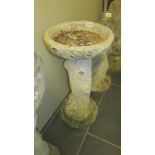 A vintage bird bath with simulated bark