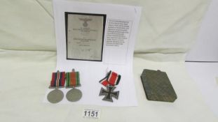 A Nazi era iron cross and an unused war merit cross document with printed signature of Adolf Hitler