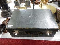 A leather fitted suitcase with enamelled contents