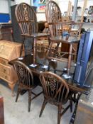 A oak drawer leaf table and 6 wheel back chairs