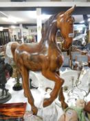 A large solid polished teak model of a horse