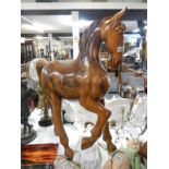 A large solid polished teak model of a horse