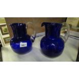 A pair of Bristol blue glass jugs with clear glass reeded handles