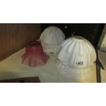 A pair of 1930's white glass lampshades and a cranberry glass lampshade