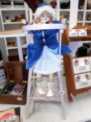 A porcelain collectors doll on a 1950's dolls wooden highchair