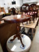 A dark wood stained tripod table with decorative top