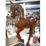 A large solid polished teak model of a horse
