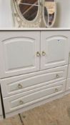 A white 2 door cabinet with 2 drawers