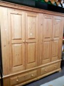 A large 4 door, 2 drawer pine wardrobe