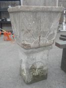 A stone garden planter on stone plinth