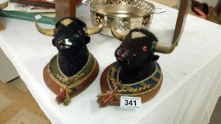 A pair of miniature bulls heads on plaque