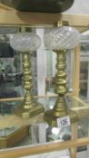 A pair of Victorian brass candlesticks with vaseline glass peg fonts