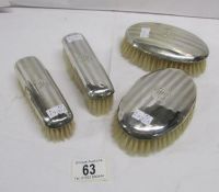 4 engine turned silver backed brushes,