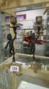 A pair of cherub candlesticks with brass mounts