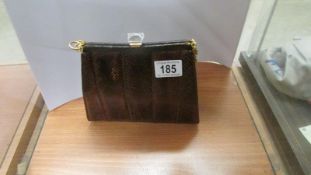 A vintage brown snakeskin hand bag with yellow metal shoulder chain