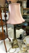 A brass Corinthian column table lamp with shade