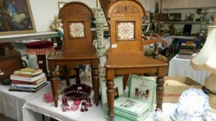 A pair of late 19th century oak hall chairs with tile inset in back